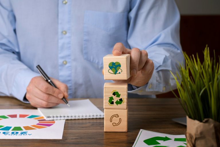 Gestor de condomínio planejando ESG em condomínios com símbolos de sustentabilidade sobre mesa de trabalho