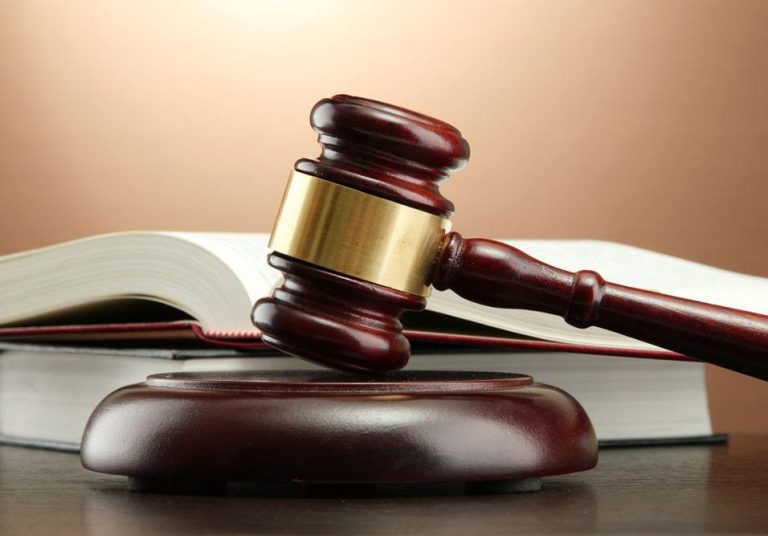 Martelo de juiz e código civil representando decisão STJ sobre dívidas condominiais em recuperação judicial e impacto na gestão condominial