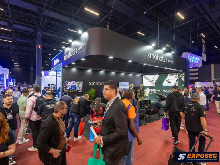 Estande de segurança eletrônica na Exposec 2026 com profissionais analisando inovações em tecnologia para facilities management e terceirização