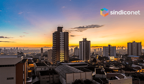 Skyline urbano ao entardecer com prédios residenciais e comerciais para gestão condominial e facilities management